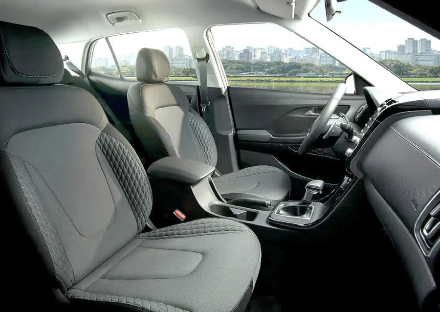 O interior traz ar automático, saída traseira, chave presencial e porta malas de 422 litros, criando um ambiente prático que reduz desgaste em trajetos longos.