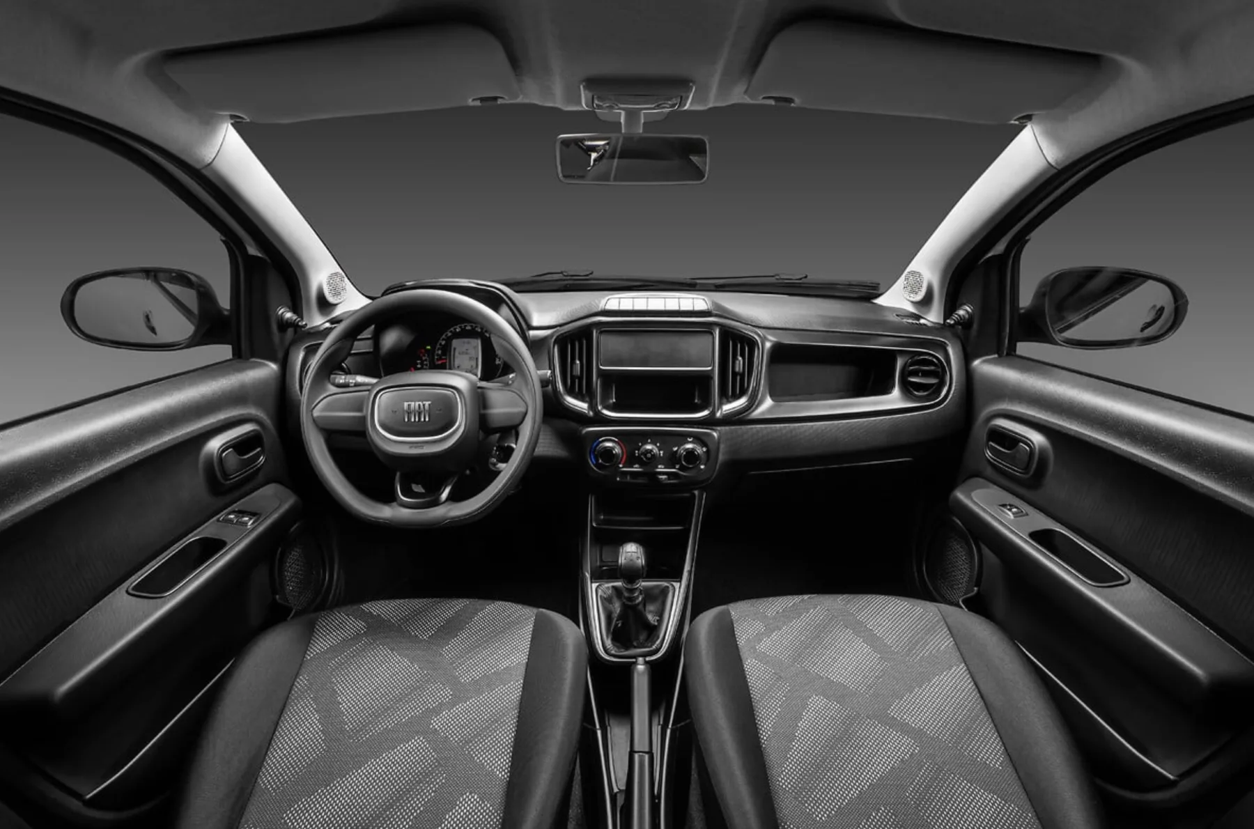 O interior é simples e honesto. Ar-condicionado, direção elétrica e itens básicos resolvem o dia a dia, mas espaço e silêncio são limitados.