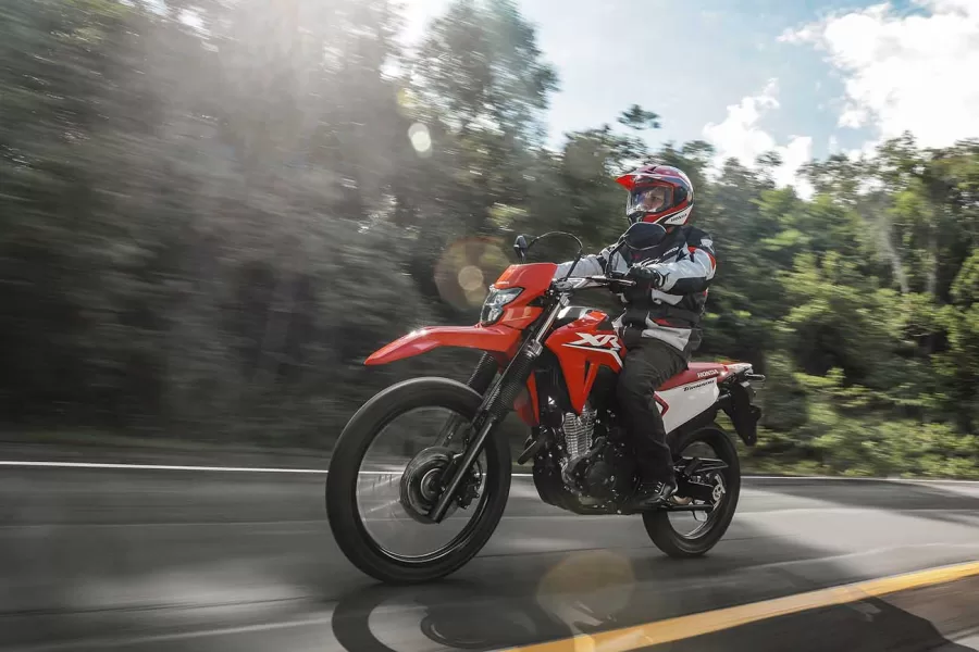 A XR 300L Tornado possui banco plano para facilitar a movimentação do piloto e partes plásticas laterais que protegem o tanque de metal. O para-lama elevado e o conjunto ótico minimalista reforçam o caráter off-road.