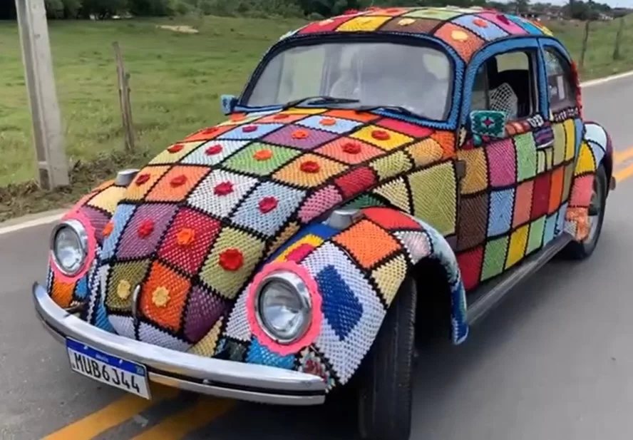 A transformação do Fusca em uma peça de crochê levou sete meses e foi feita à mão. A ideia nasceu como uma forma de enfrentar desafios emocionais, resultando em um carro único e colorido - Foto: Reprodução/Instagram @fusca.fuxico