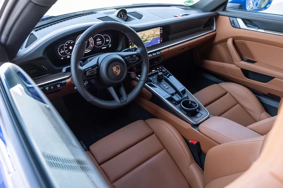 O interior do Porsche 911 Carrera oferece luxo e funcionalidade, com acabamentos personalizados, materiais de alta qualidade e tecnologia de ponta para uma experiência de condução refinada.