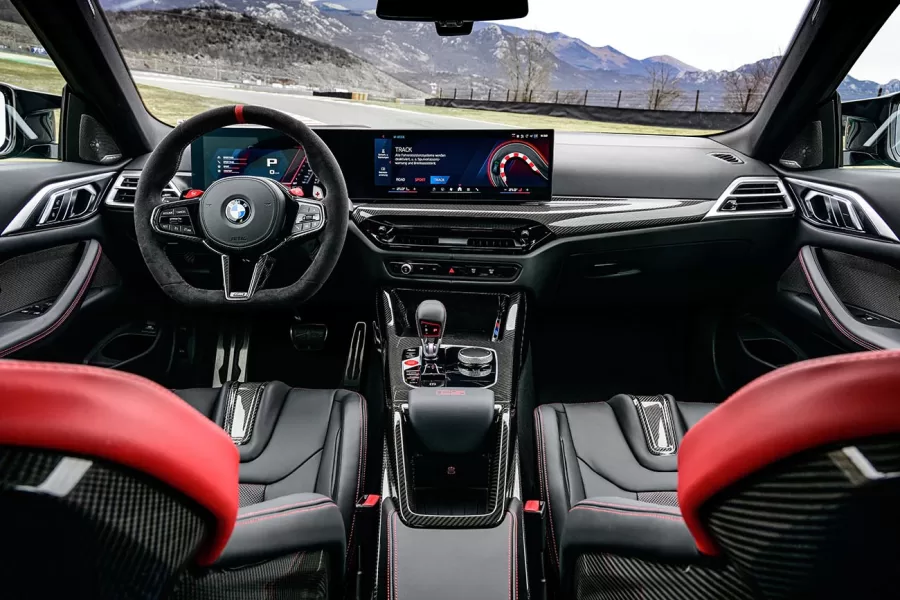 O interior do BMW M4 CS combina luxo e funcionalidade, com assentos M Carbon e acabamento refinado. O tapete de veludo no interior destaca a exclusividade do modelo, criando um ambiente diferenciado.