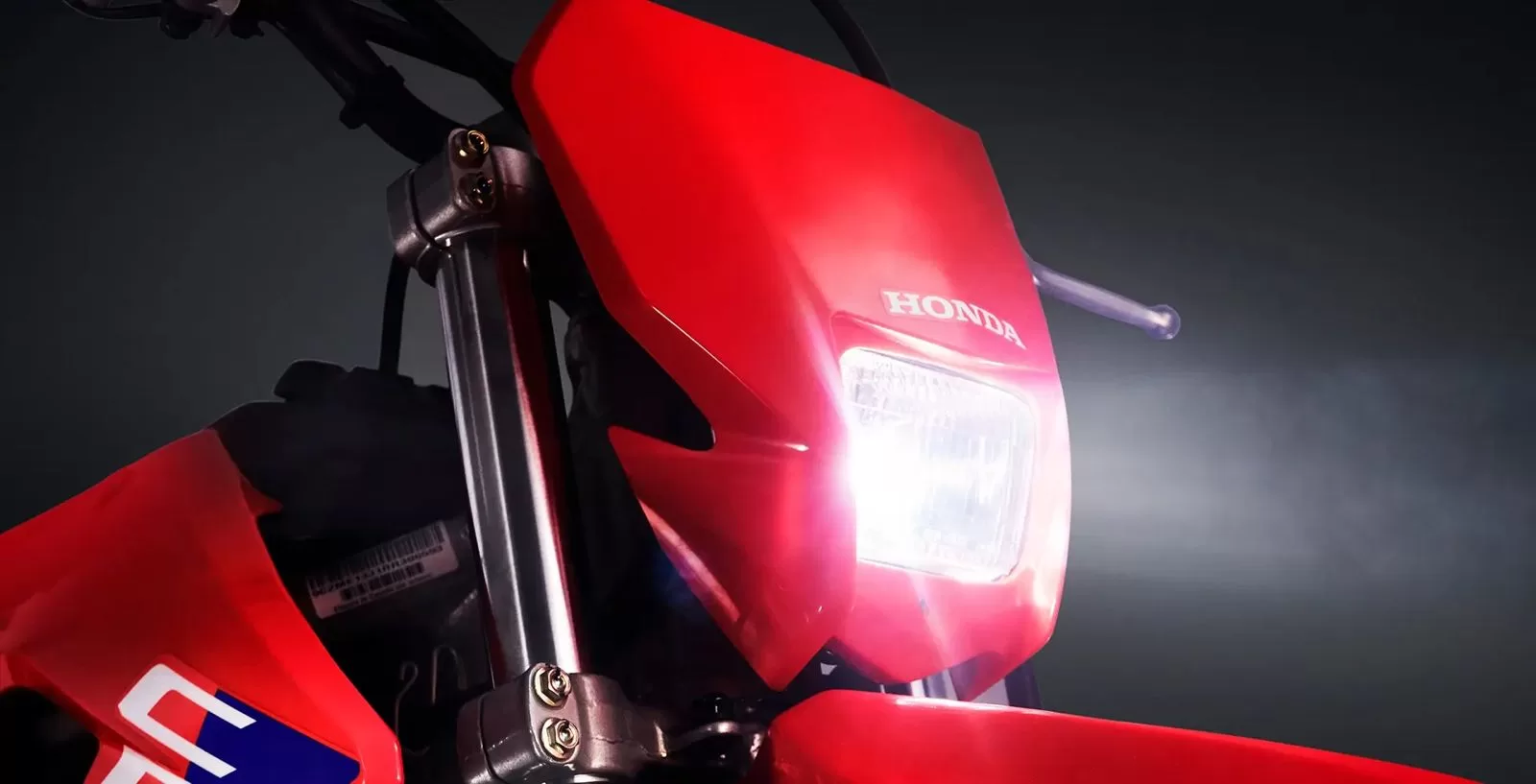 A Honda CRF 250F está equipada com um farol de 35W, projetado para oferecer visibilidade adequada em condições de pouca iluminação.