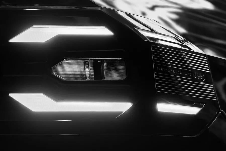 No escuro, as luzes se acendem. O novo Jeep Compass 2025 é revelado em teaser, mostrando um design renovado e mantendo a icônica grade de sete fendas, agora com iluminação segmentada.