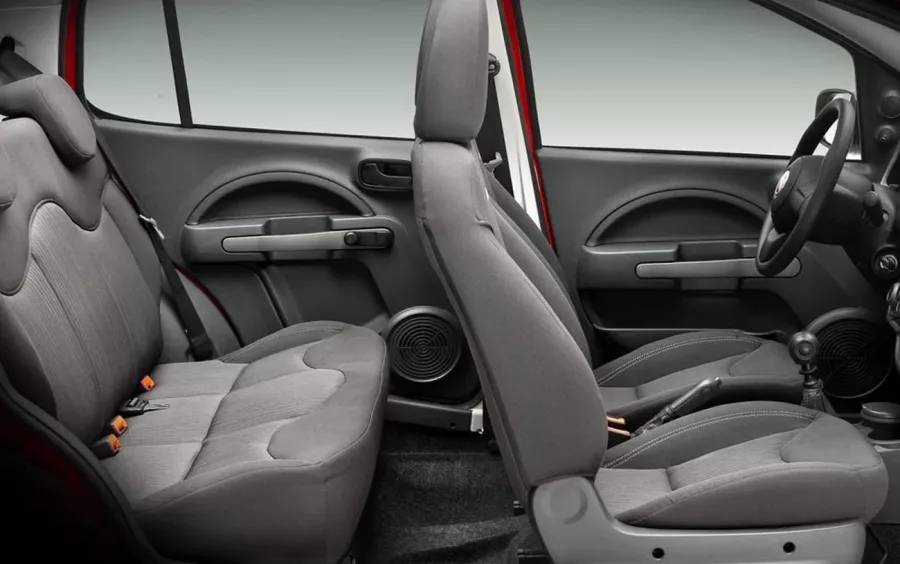 Interior compacto, acomoda 5 pessoas. Conforto básico, bancos simples e painel funcional. Segurança inclui airbags e ABS, mas não tem controle de estabilidade.