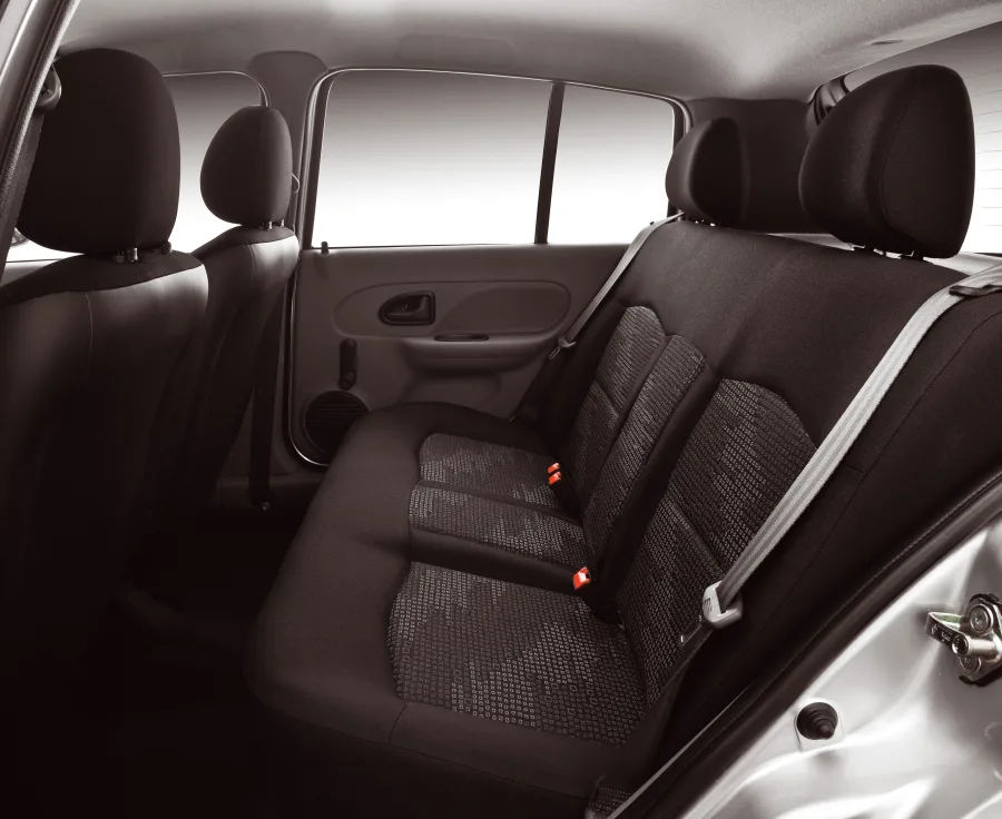 O interior tem 5 lugares e porta-malas de 255 litros, com conforto simples e posição de dirigir correta. É um carro urbano que prioriza praticidade e custo baixo.