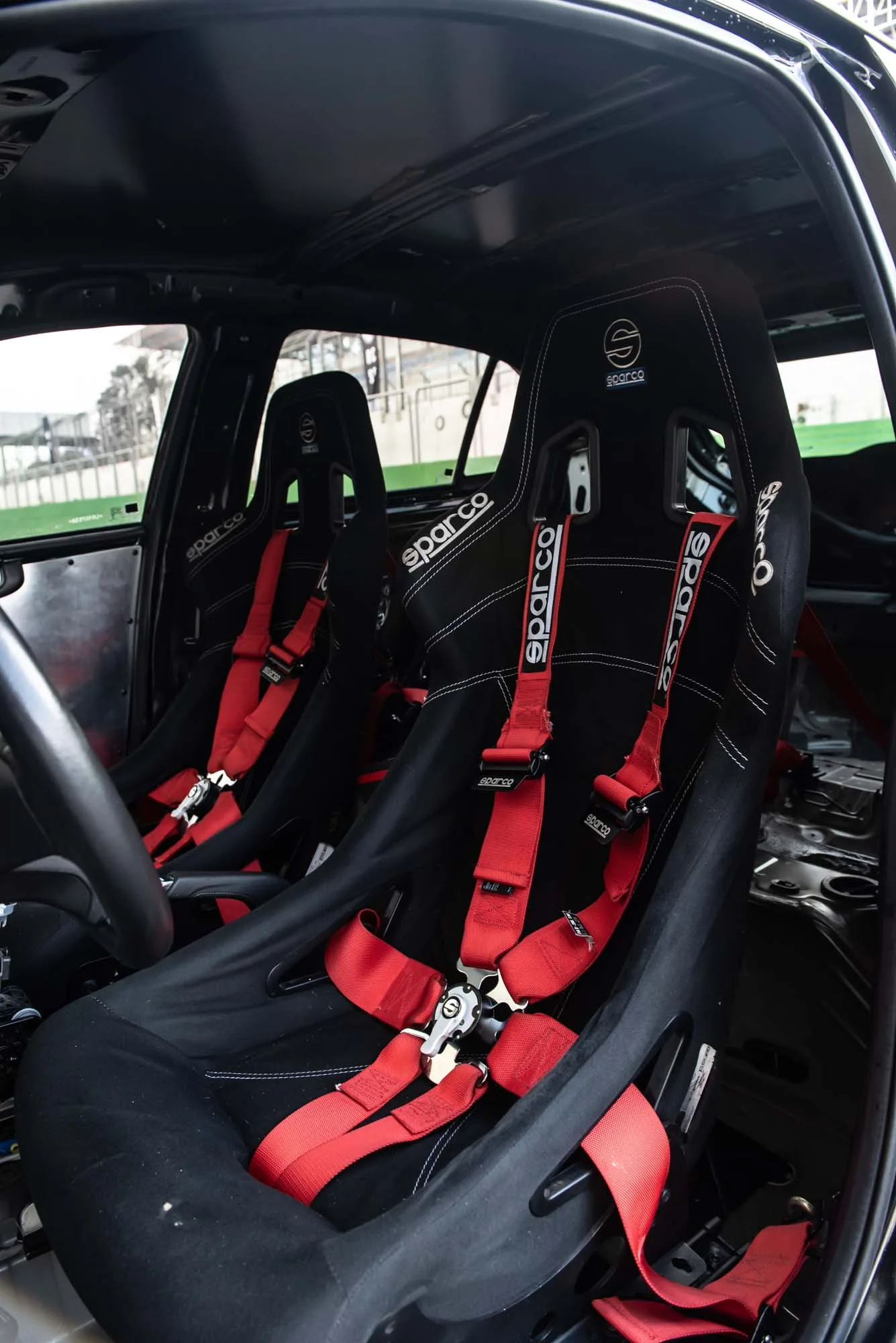 Por dentro, bancos concha com cintos de cinco pontos e menos acabamento. A redução aproximada de 150 kg muda o jeito do carro se comportar.