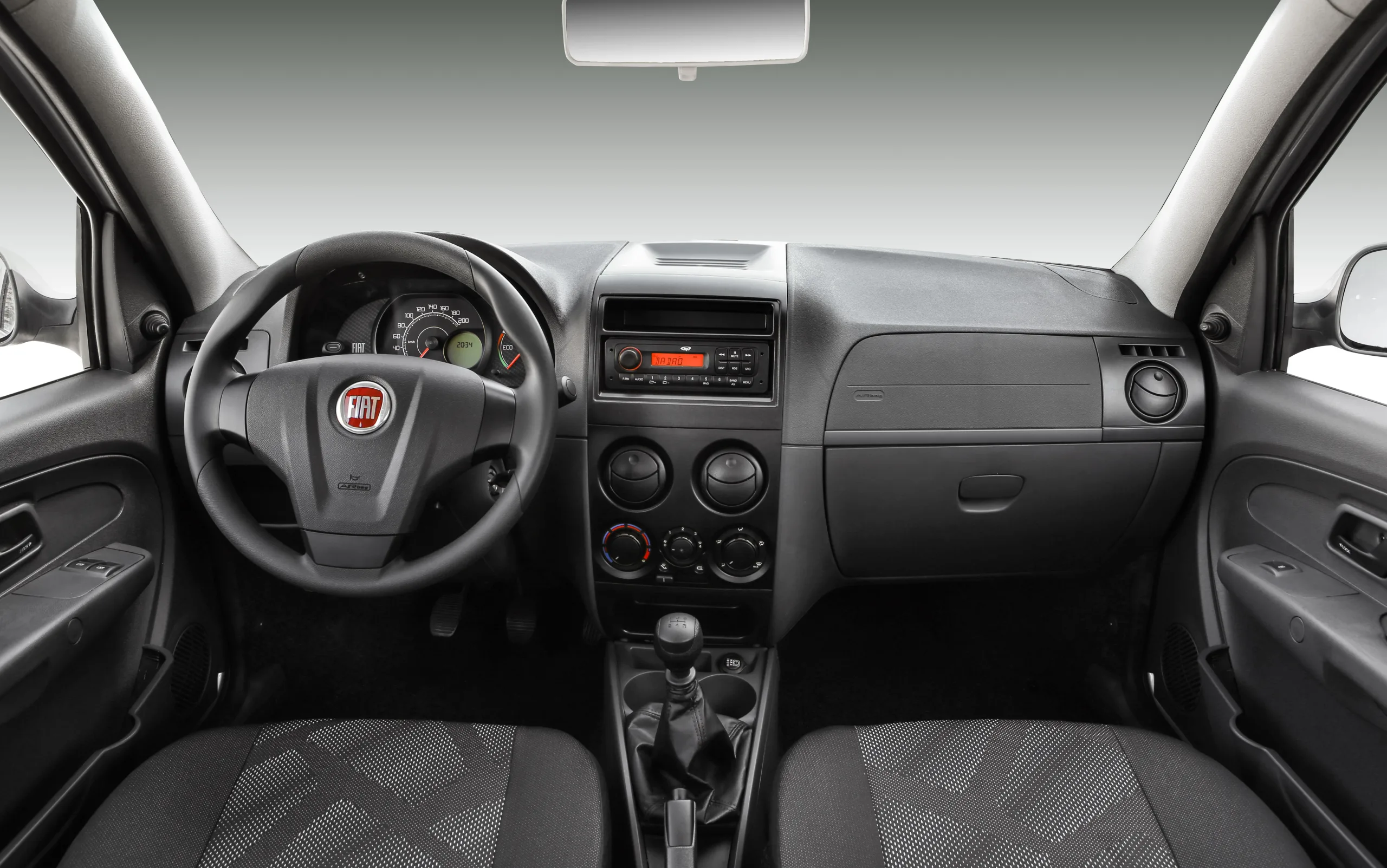 ABS, airbags frontais e tomada 12 V vêm de série; ar, vidros elétricos, rádio, USB, travas e limpador traseiro dependem da versão.