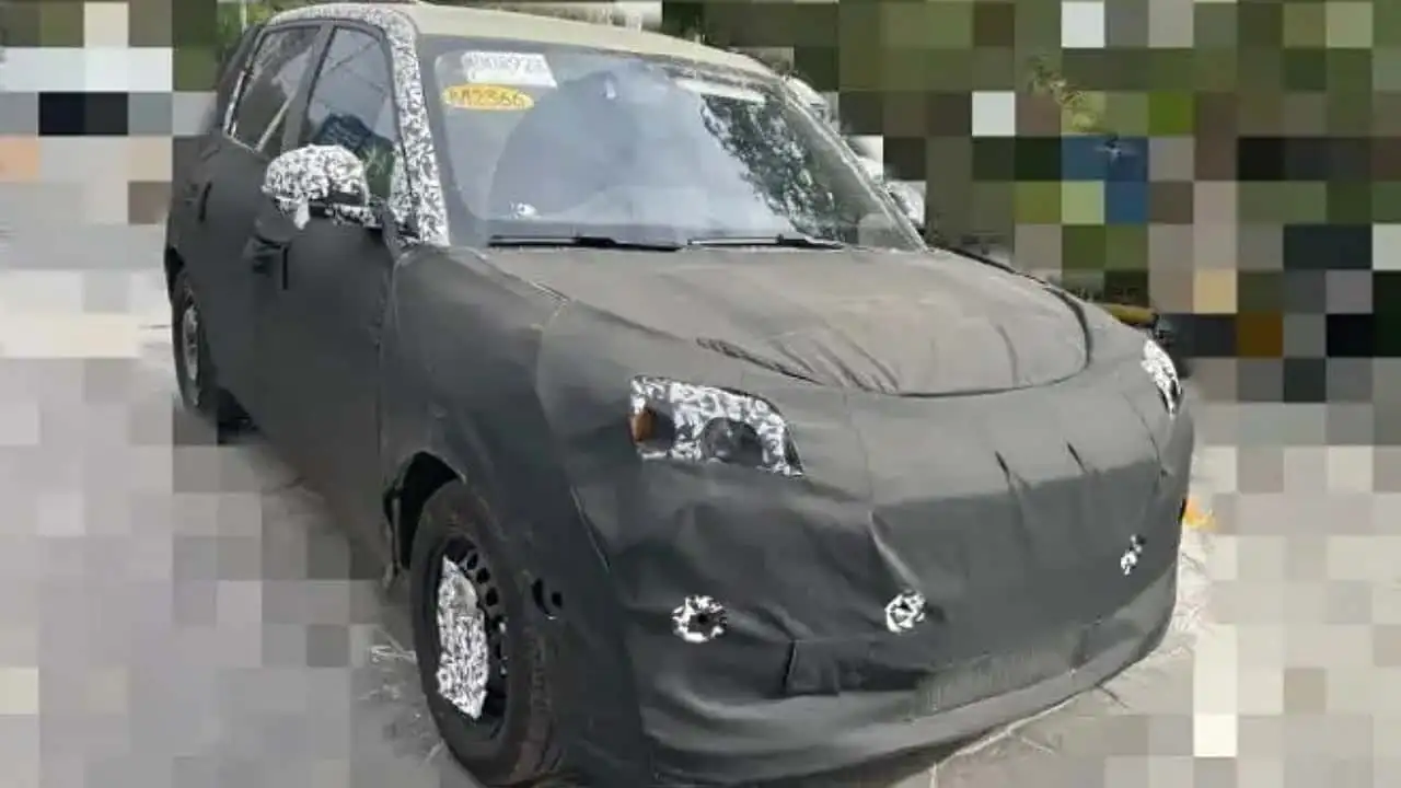 O E211 apareceu camuflado na China e terá porte menor que o EX2, com carroceria alta, capô curto, teto quase reto e proposta voltada ao trânsito urbano e ao baixo custo.